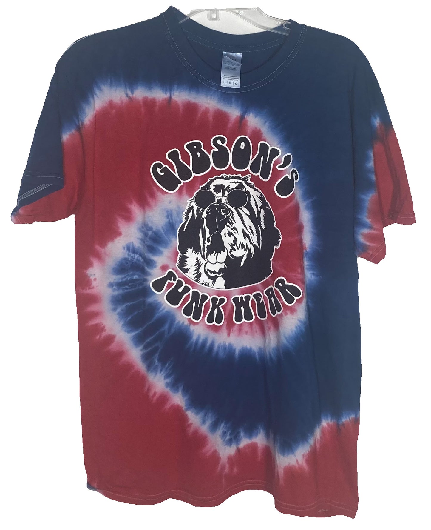 Alt text: "Gibson's Funk Wear tie-dye T-shirt in red and blue vertigo pattern featuring a central graphic of a shaggy dog wearing sunglasses, with the text 'Gibson's Funk Wear' above and 'J