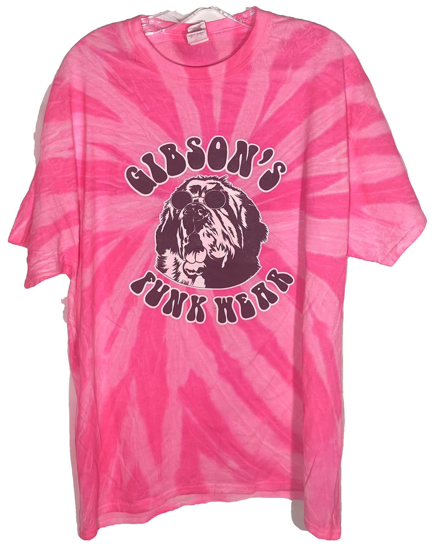 Alt text: "Hot pink tie-dye Gibsons Funk Wear T-shirt featuring a graphic of a dog wearing sunglasses and the text 'GIBSON'S JUNK HEAR'."