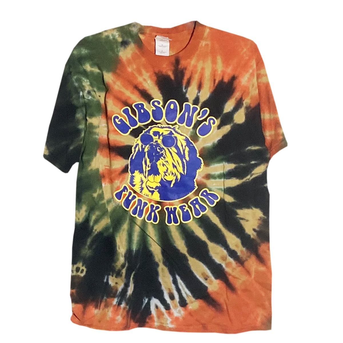 Alt text: "Colorful tie-dye T-shirt from Gibson's Funk Wear featuring an Earth Day theme. The shirt has vibrant swirls of green, orange, and black with a central graphic of a blue and yellow logo that reads 'Gib